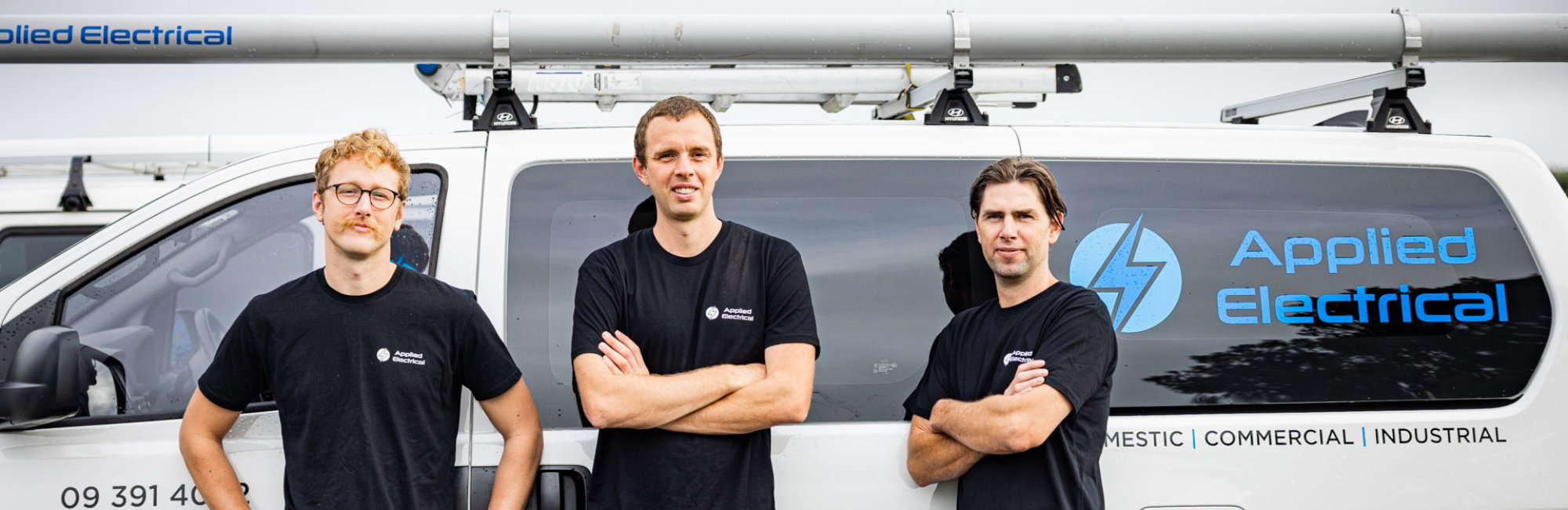 The Applied Electrical team — Patrick, Tyler, and Sean in front of the company van