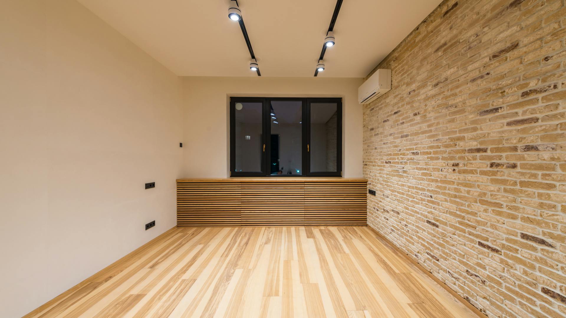 Modern room with recessed LED downlights and brick accent wall